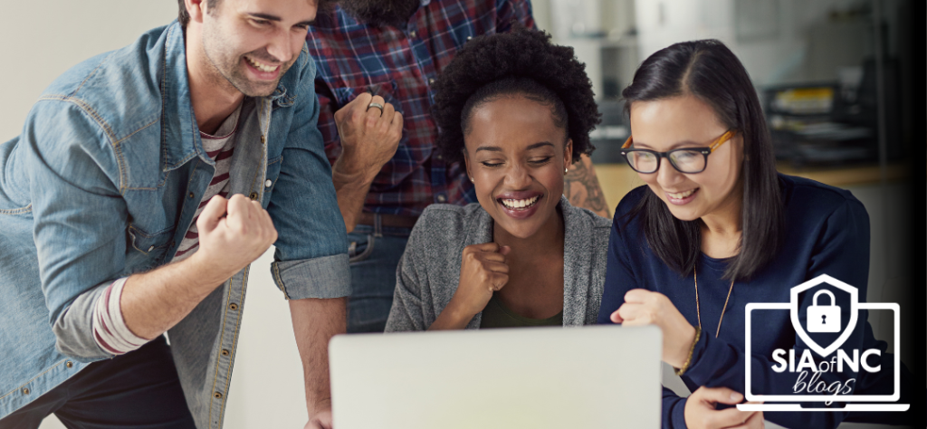 stock photo of mixed variety of 2 men and 2 women excitedly staring at their computer screen for employee benefits